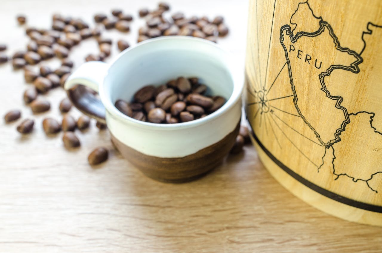 Close-up of fresh roasted coffee beans in a cup with a map of Peru. Perfect for café themes.